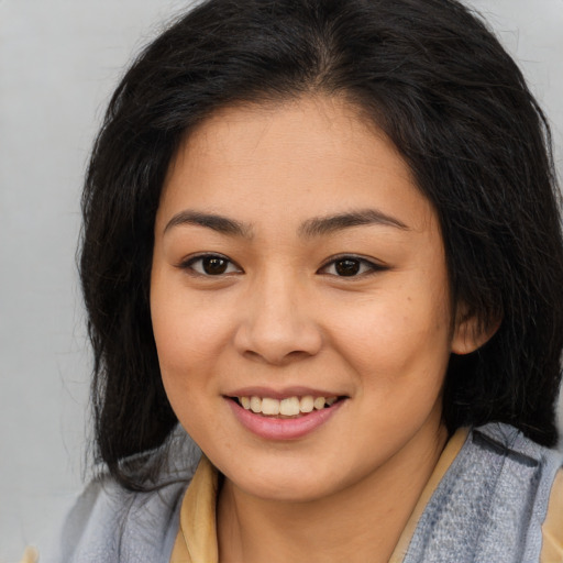 Joyful asian young-adult female with long  brown hair and brown eyes