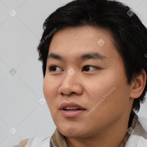 Joyful asian young-adult male with short  black hair and brown eyes