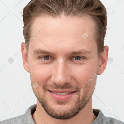 Joyful white young-adult male with short  brown hair and grey eyes