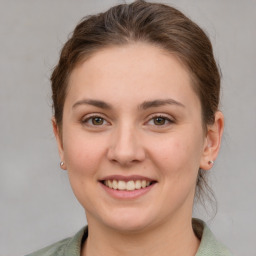 Joyful white young-adult female with medium  brown hair and grey eyes