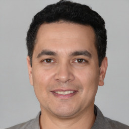 Joyful white adult male with short  black hair and brown eyes