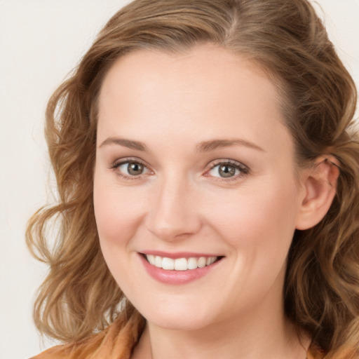 Joyful white young-adult female with long  brown hair and blue eyes