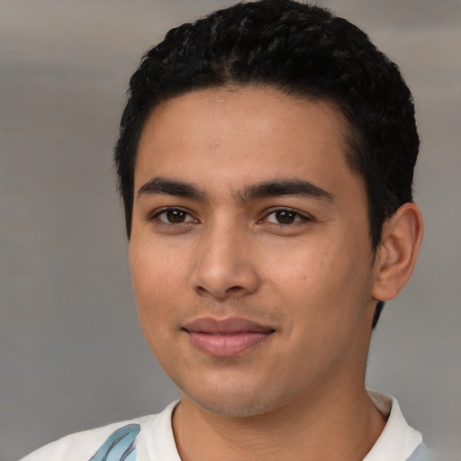 Joyful latino young-adult male with short  black hair and brown eyes