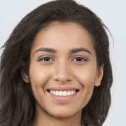 Joyful latino young-adult female with long  brown hair and brown eyes