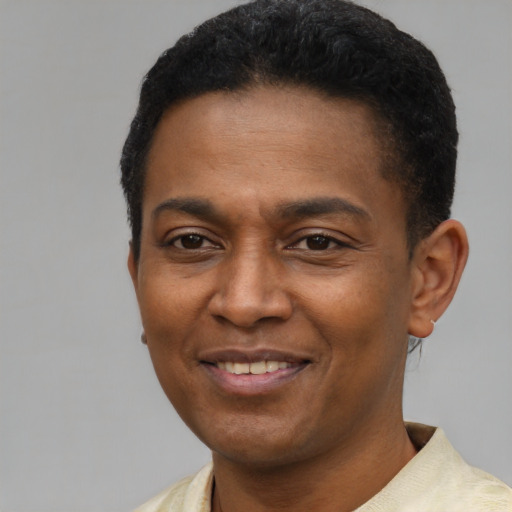 Joyful latino young-adult male with short  brown hair and brown eyes