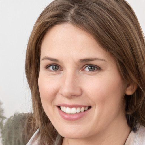 Joyful white young-adult female with medium  brown hair and grey eyes