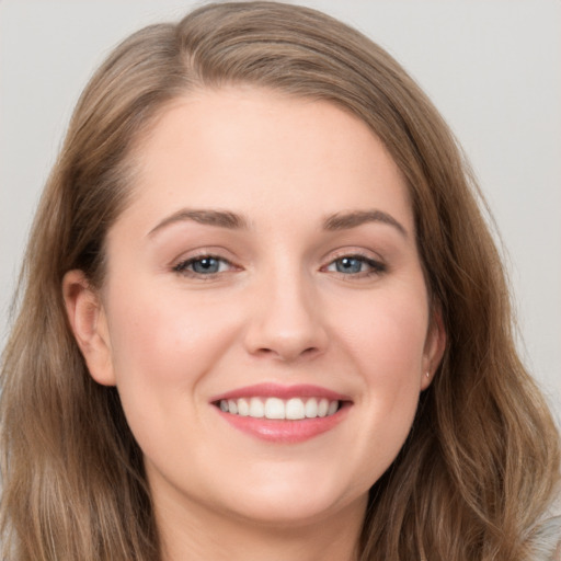 Joyful white young-adult female with long  brown hair and grey eyes