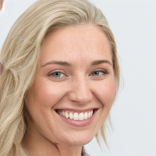 Joyful white young-adult female with long  blond hair and blue eyes