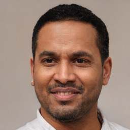 Joyful latino adult male with short  black hair and brown eyes
