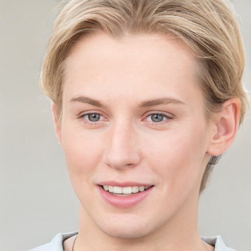 Joyful white young-adult female with short  brown hair and blue eyes