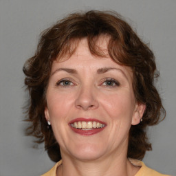 Joyful white adult female with medium  brown hair and blue eyes