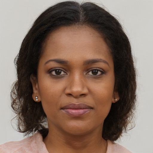 Joyful black young-adult female with medium  brown hair and brown eyes