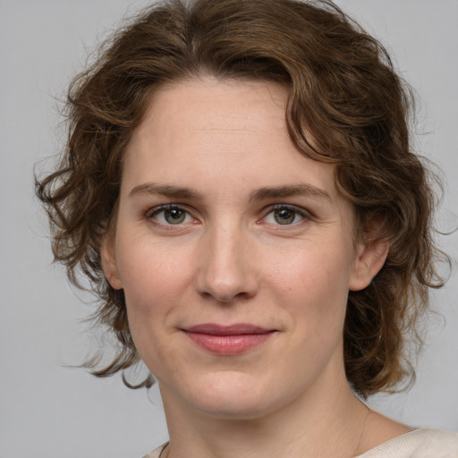 Joyful white young-adult female with medium  brown hair and green eyes