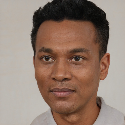 Joyful black young-adult male with short  black hair and brown eyes