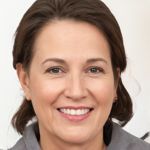 Joyful white adult female with medium  brown hair and brown eyes