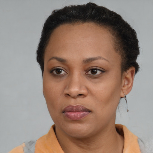 Joyful black adult female with short  brown hair and brown eyes