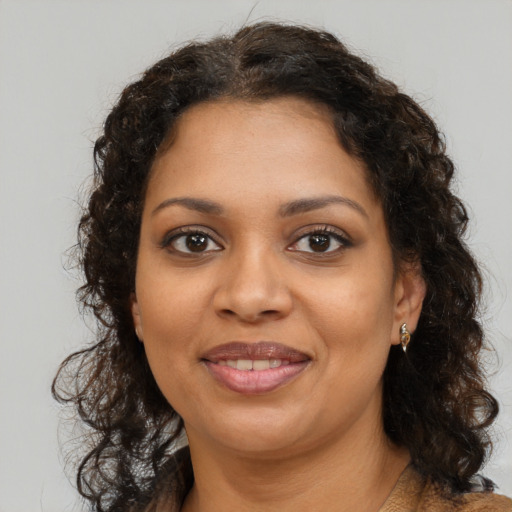 Joyful black young-adult female with medium  brown hair and brown eyes