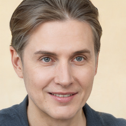 Joyful white adult male with short  brown hair and grey eyes