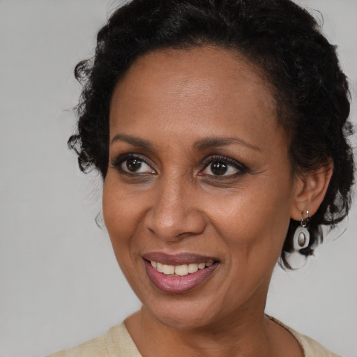 Joyful black adult female with medium  brown hair and brown eyes