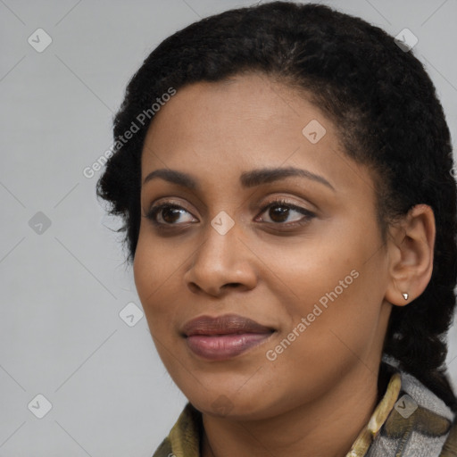 Joyful black young-adult female with long  black hair and brown eyes