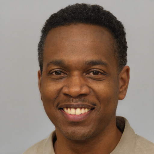 Joyful black adult male with short  black hair and brown eyes
