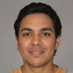 Joyful latino young-adult male with short  black hair and brown eyes