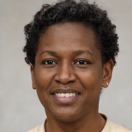 Joyful black young-adult female with short  brown hair and brown eyes