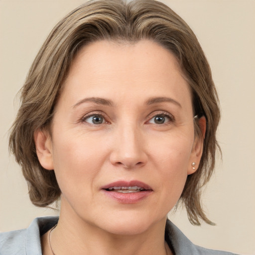 Joyful white adult female with medium  brown hair and grey eyes