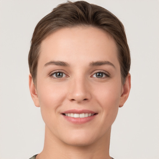 Joyful white young-adult female with short  brown hair and grey eyes