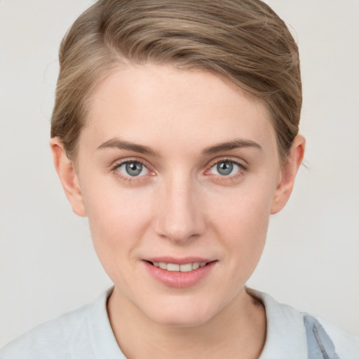 Joyful white young-adult female with short  brown hair and grey eyes