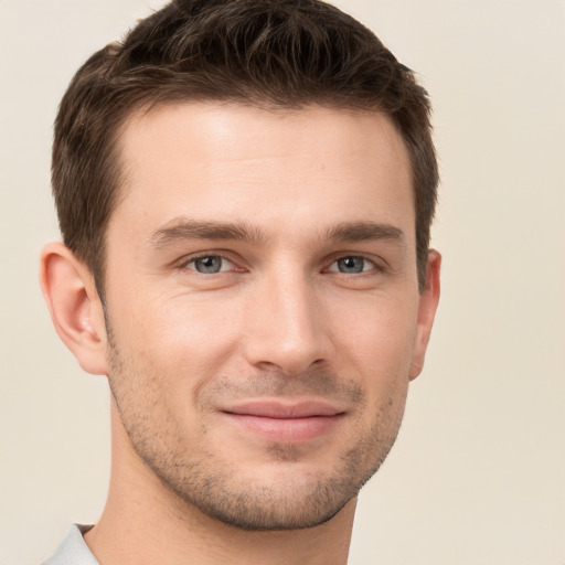 Joyful white young-adult male with short  brown hair and grey eyes