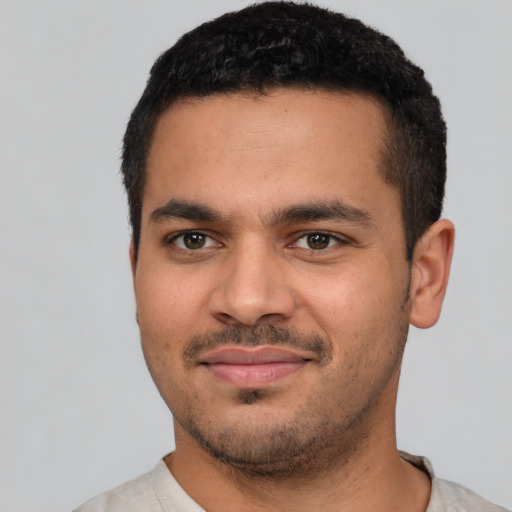 Joyful latino young-adult male with short  black hair and brown eyes