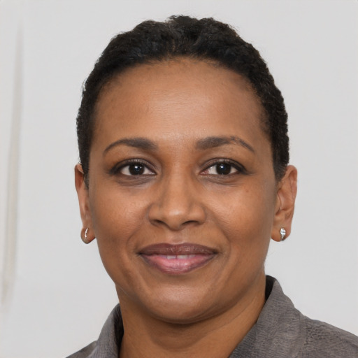 Joyful black adult female with short  black hair and brown eyes