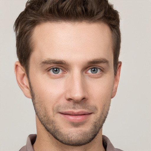 Joyful white young-adult male with short  brown hair and grey eyes