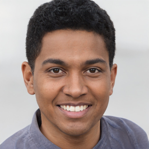 Joyful black young-adult male with short  brown hair and brown eyes