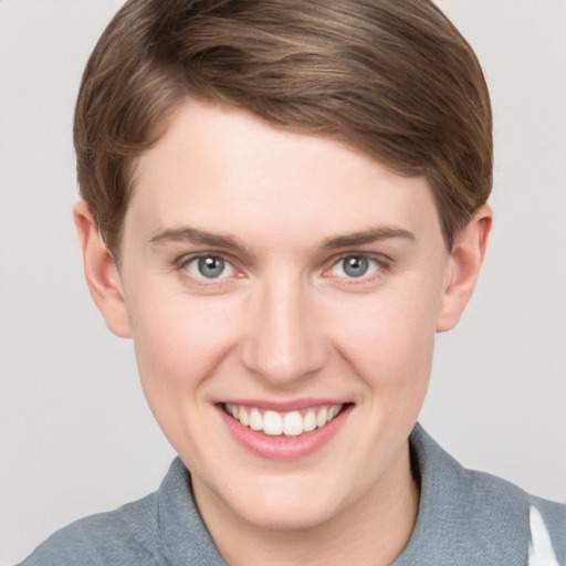 Joyful white young-adult female with short  brown hair and grey eyes