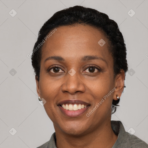 Joyful black adult female with short  black hair and brown eyes