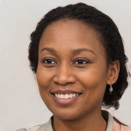 Joyful black young-adult female with medium  black hair and brown eyes