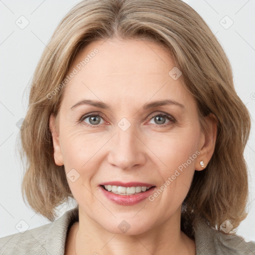 Joyful white adult female with medium  brown hair and grey eyes