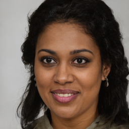 Joyful black young-adult female with long  brown hair and brown eyes