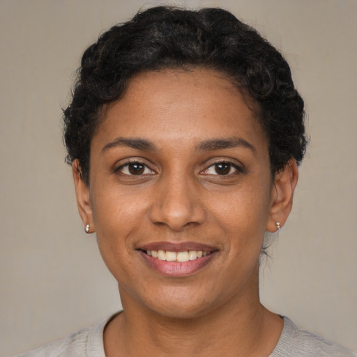 Joyful black young-adult female with short  black hair and brown eyes