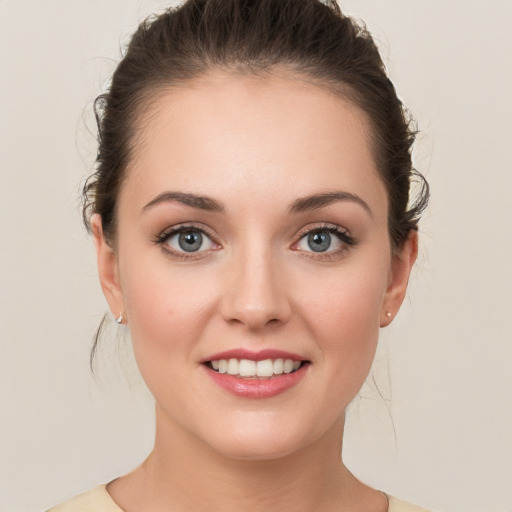 Joyful white young-adult female with medium  brown hair and grey eyes