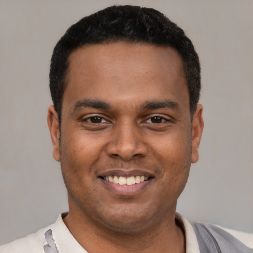 Joyful latino young-adult male with short  black hair and brown eyes