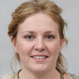 Joyful white young-adult female with medium  brown hair and blue eyes