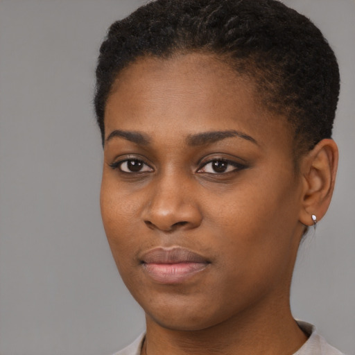 Joyful black young-adult female with short  black hair and brown eyes