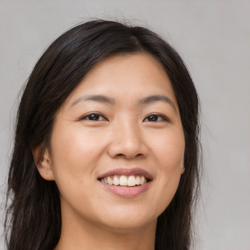 Joyful asian young-adult female with long  brown hair and brown eyes