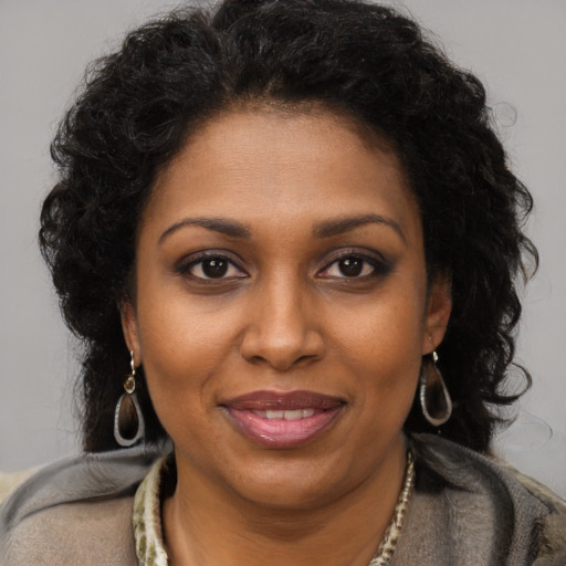 Joyful black young-adult female with long  brown hair and brown eyes