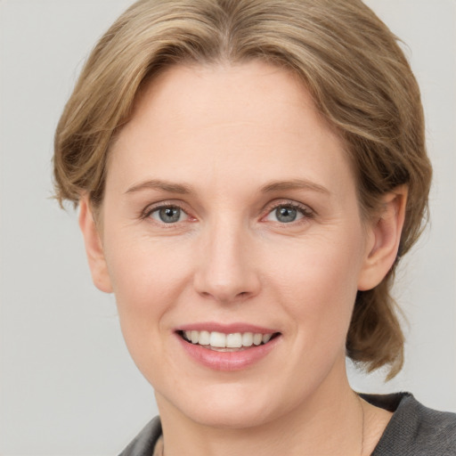 Joyful white young-adult female with medium  brown hair and blue eyes