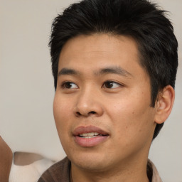 Joyful asian young-adult male with short  brown hair and brown eyes