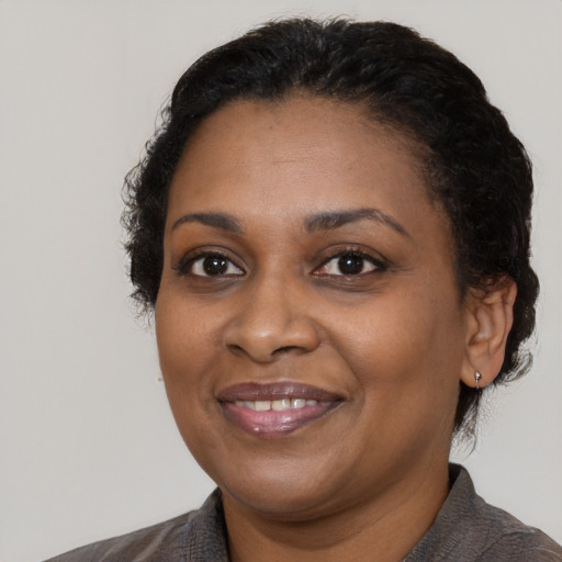 Joyful black adult female with short  black hair and brown eyes